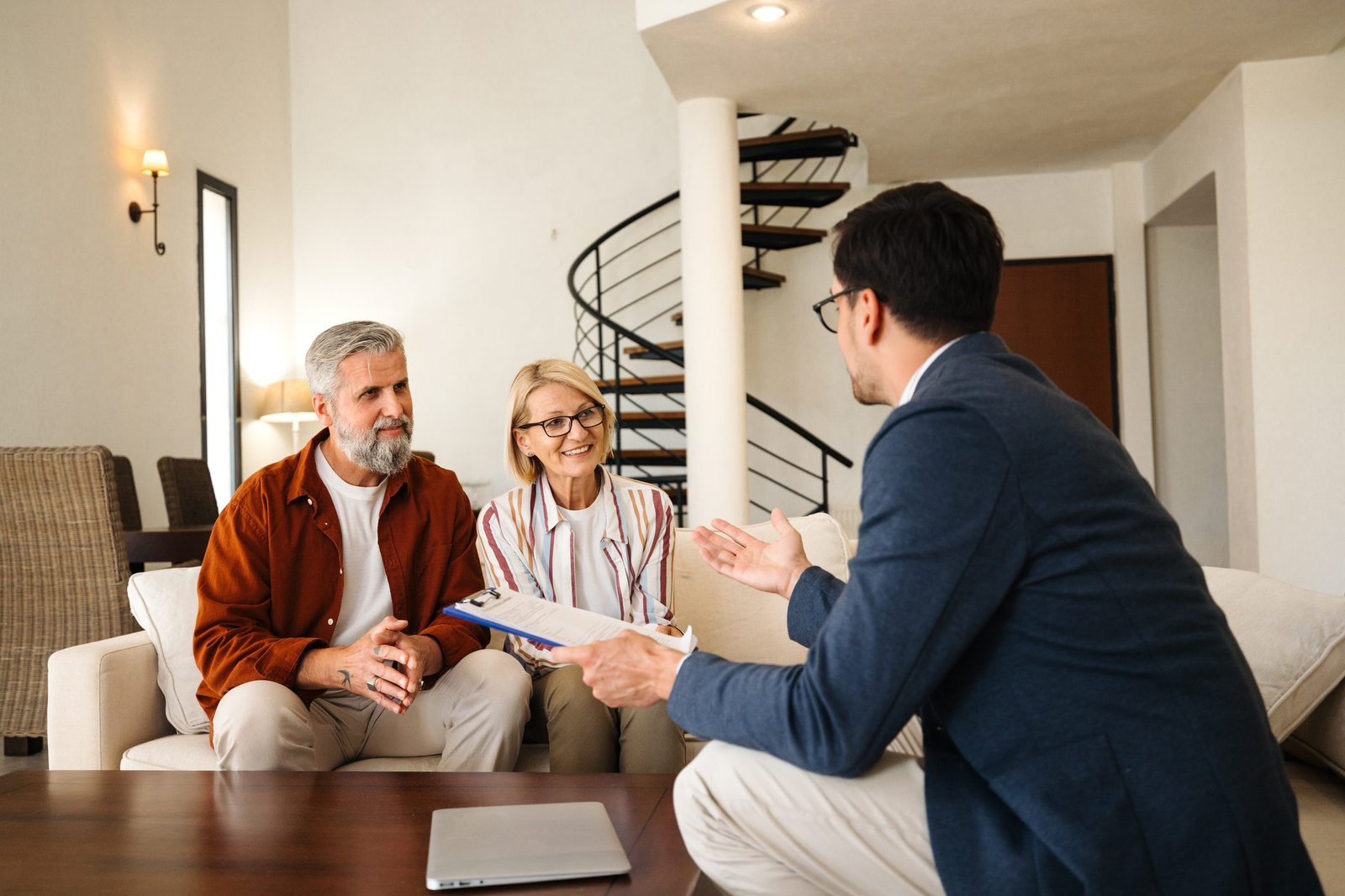 Couple meeting with advisor in living room.